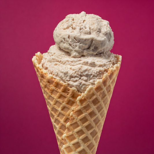 Ice cream cone with two scoops of light-colored ice cream against a pink background